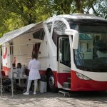 Ônibus móvel do Hemosul estacionado em área pública para campanha de doação de sangue em Campo Grande