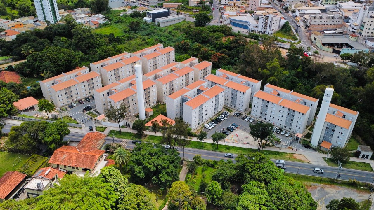 Vista aérea de um conjunto de prédios residenciais cercado por áreas verdes.